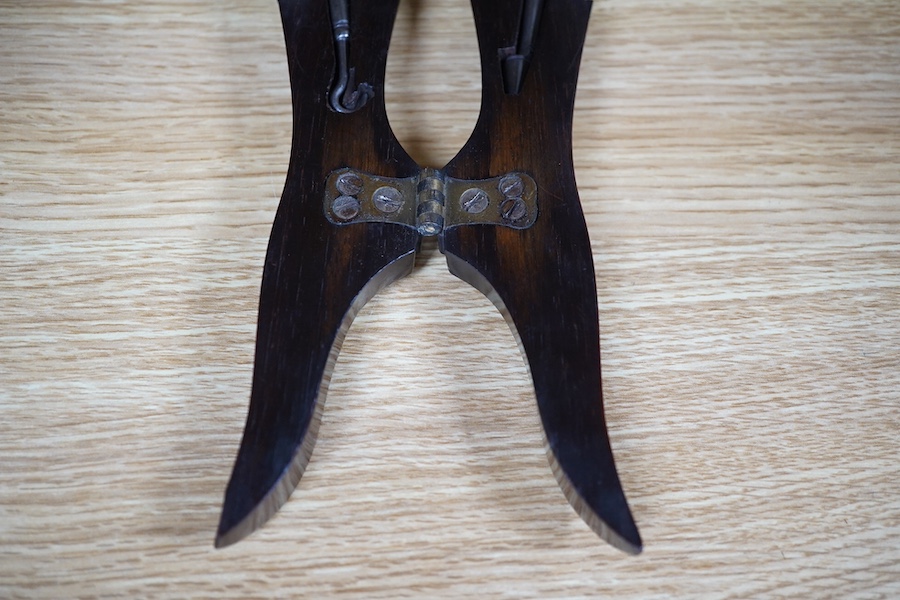 A Victorian rosewood 'ladys foot' etui holding a pair of steel bootpulls with additional tools to the handle, 26.5cm. Condition - good